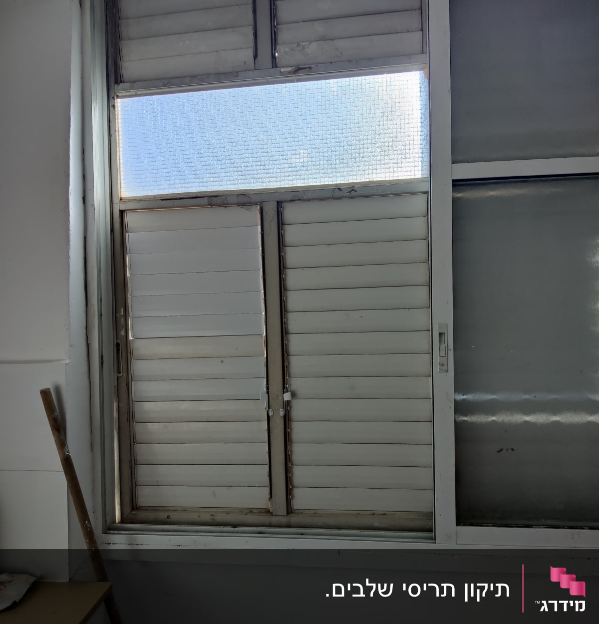 תריסים לבנים סגורים עם חלון זכוכית עליון